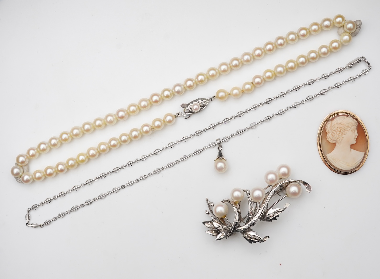 A collection of cultured pearl jewels and a cameo pendant